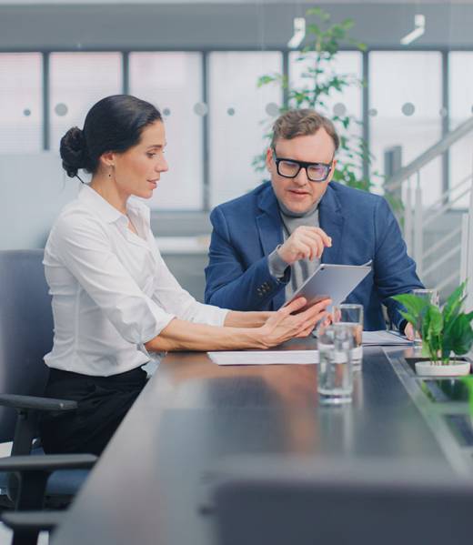 Two individuals are looking at a tablet